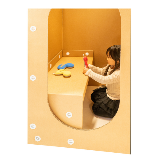 ダンボール カームダウンルームの中で遊ぶ子供